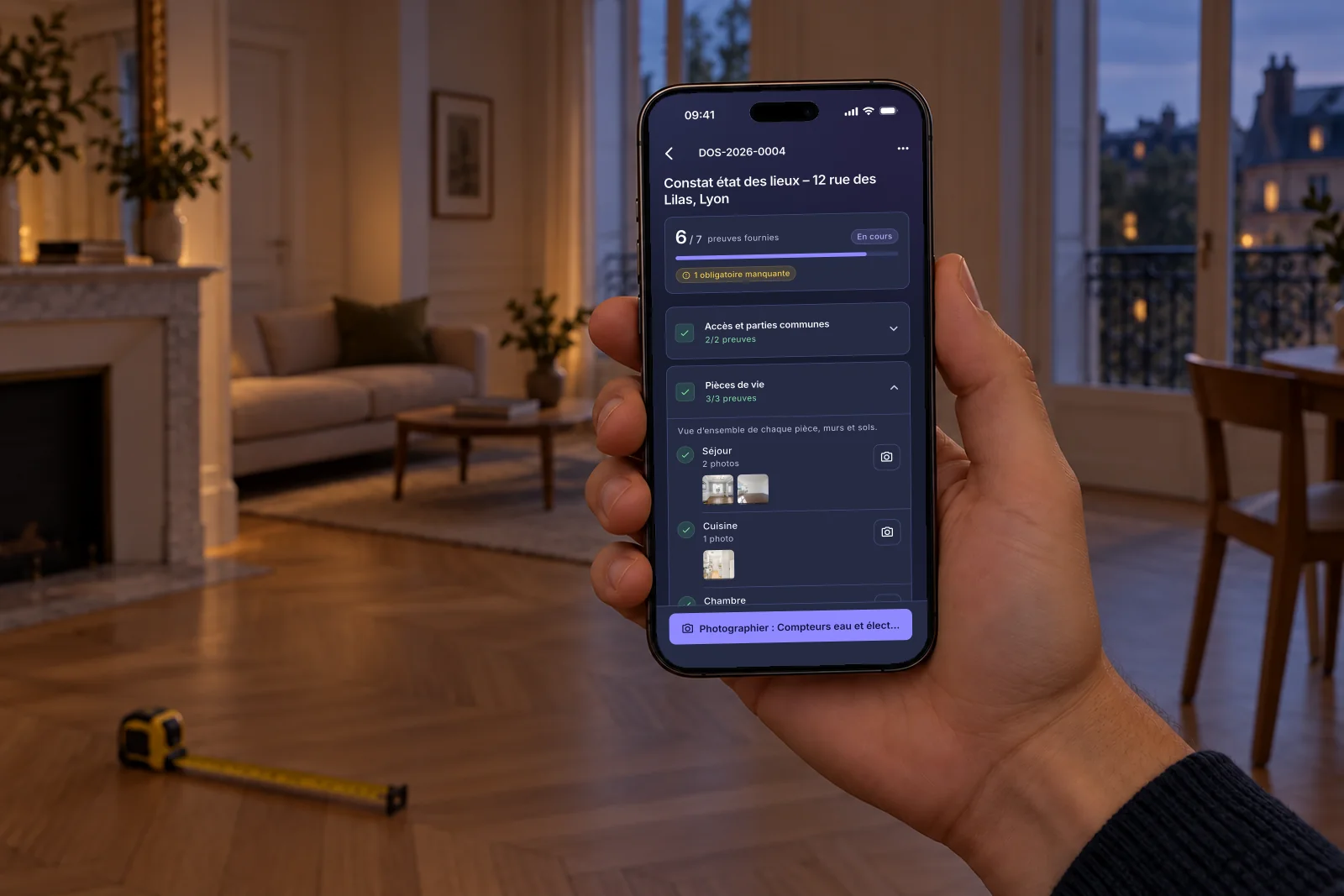Une main tient un téléphone qui affiche un état des lieux en cours dans l’application Givre