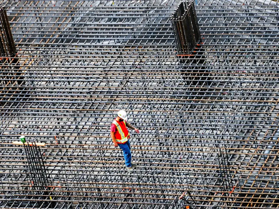 Un technicien inspecte les armatures d’une dalle sur un chantier